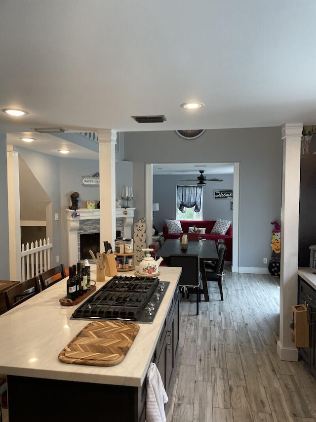 kitchen featuring black gas stovetop, a center island, ceiling fan, and light hardwood / wood-style floors