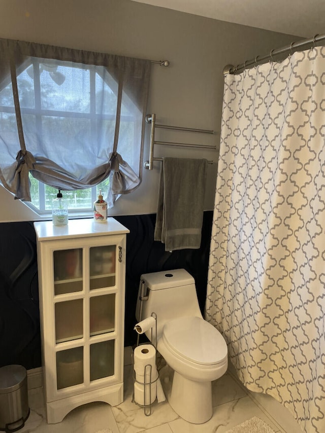 bathroom featuring curtained shower and toilet