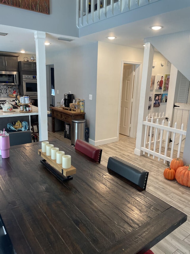 dining area featuring a high ceiling and hardwood / wood-style flooring