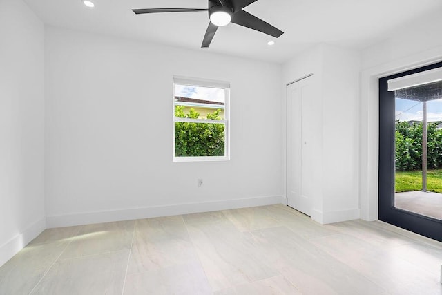 empty room featuring light tile patterned flooring, plenty of natural light, and ceiling fan