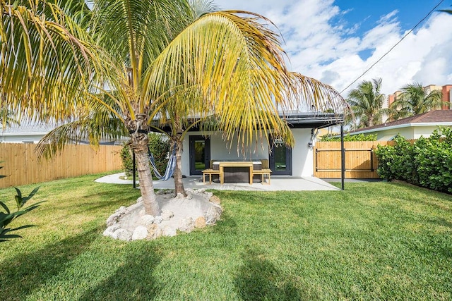 rear view of house featuring a yard and a patio