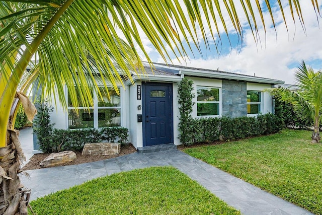 entrance to property featuring a yard