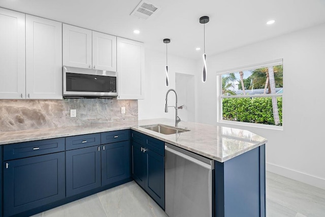 kitchen with blue cabinetry, sink, hanging light fixtures, stainless steel appliances, and white cabinets