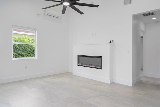 unfurnished living room featuring a wall mounted AC and ceiling fan