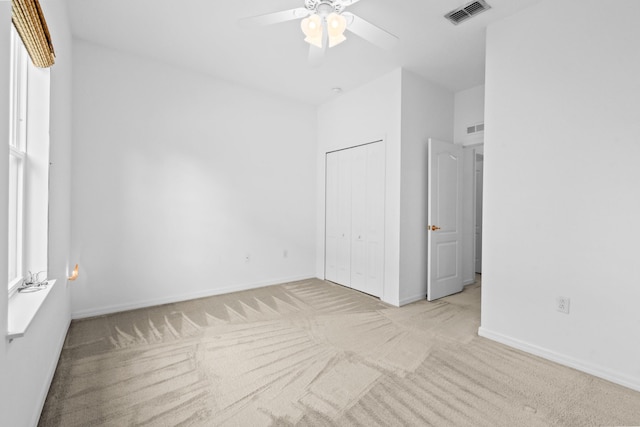 spare room with ceiling fan and light colored carpet