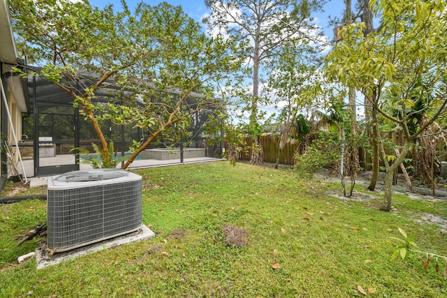 view of yard featuring a lanai and central AC unit