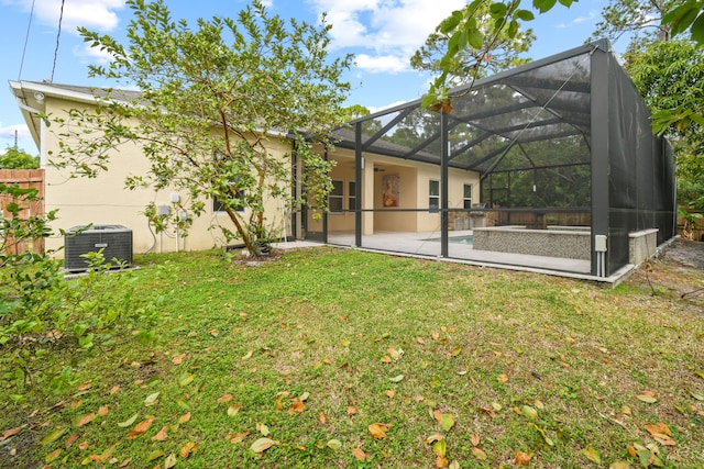 view of yard featuring central air condition unit, glass enclosure, and a patio