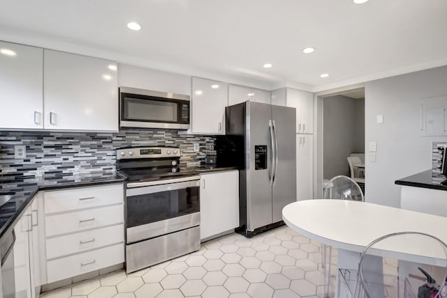 kitchen featuring white cabinets, decorative backsplash, and stainless steel appliances