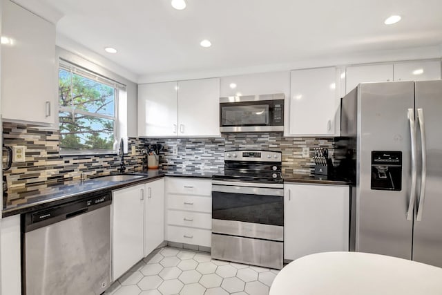 kitchen featuring white cabinetry, sink, appliances with stainless steel finishes, and tasteful backsplash