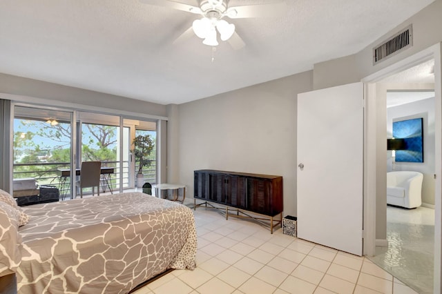 bedroom featuring ceiling fan, access to exterior, light tile patterned floors, and a textured ceiling