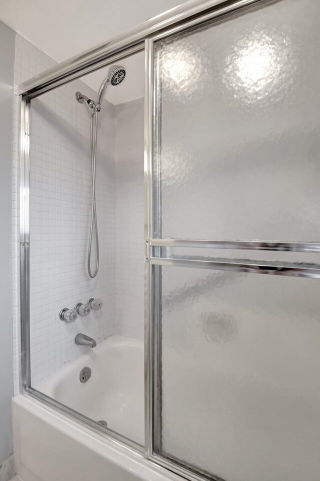 bathroom with shower / bath combination with glass door