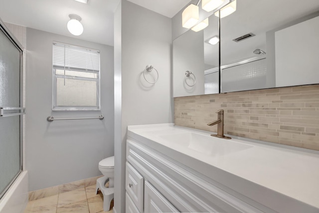 full bathroom with decorative backsplash, vanity, toilet, and bath / shower combo with glass door