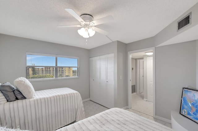 bedroom with ceiling fan, a closet, and a textured ceiling