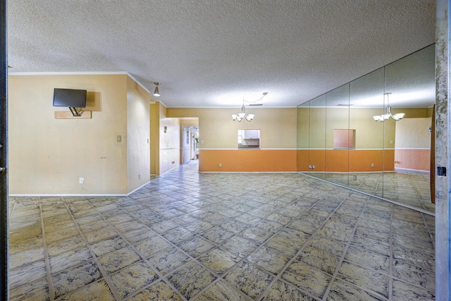 unfurnished room with ornamental molding and a notable chandelier