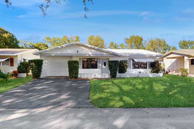 ranch-style home featuring a garage and a front lawn