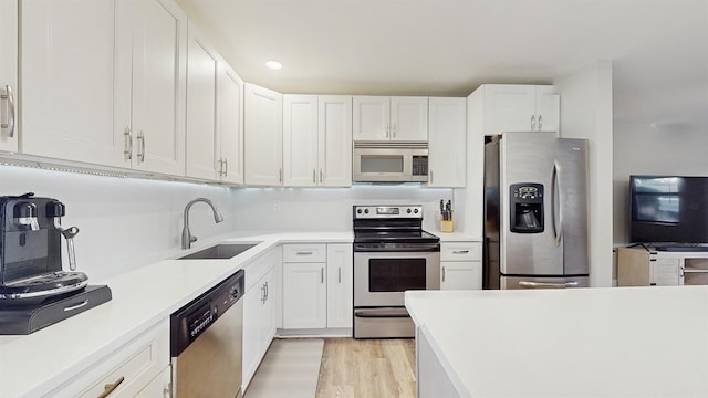 kitchen featuring sink, white cabinets, light hardwood / wood-style flooring, and appliances with stainless steel finishes