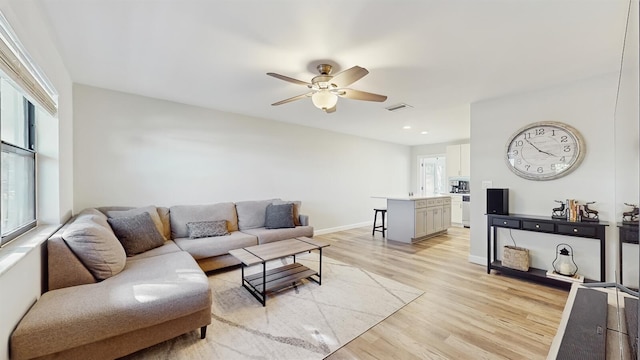 living room with ceiling fan and light hardwood / wood-style flooring