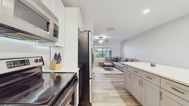 kitchen with appliances with stainless steel finishes, light hardwood / wood-style floors, and ceiling fan