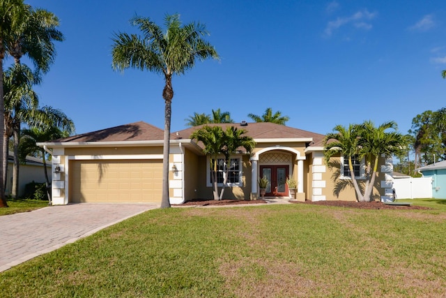 ranch-style house featuring a garage, a front yard, and french doors