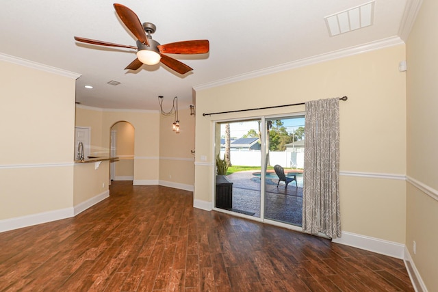 unfurnished room featuring dark hardwood / wood-style floors, ceiling fan, and crown molding