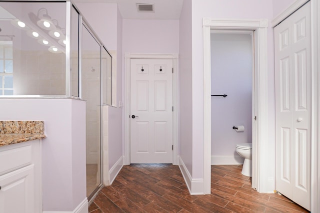 bathroom with vanity, an enclosed shower, and toilet