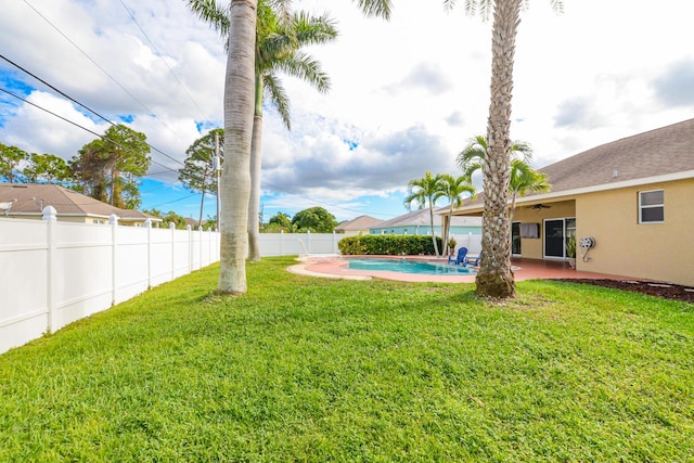 view of yard featuring ceiling fan, a patio area, and a fenced in pool