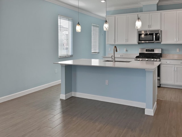 kitchen with white cabinets, sink, appliances with stainless steel finishes, and an island with sink