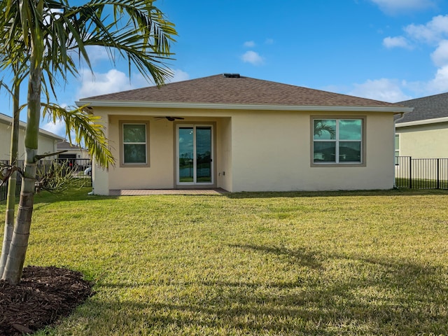 rear view of property with a yard and ceiling fan