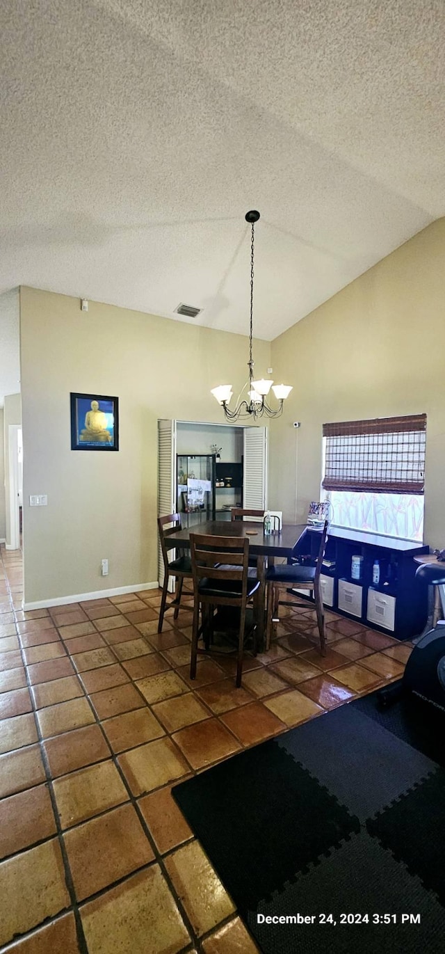 tiled dining space with vaulted ceiling, a textured ceiling, and an inviting chandelier