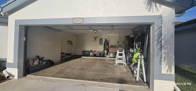 garage with a garage door opener, electric panel, and water heater