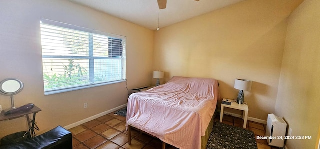 bedroom with tile patterned flooring, multiple windows, and ceiling fan