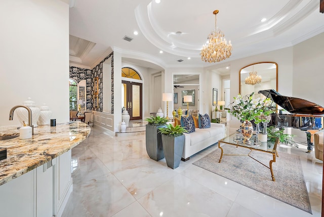 living room with a notable chandelier, crown molding, and a tray ceiling