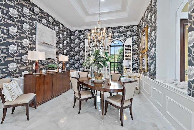 dining area featuring a tray ceiling, ornamental molding, and a notable chandelier