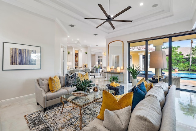 living room with a tray ceiling, ceiling fan, and ornamental molding