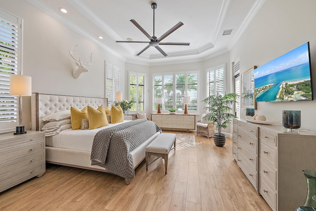 bedroom featuring light hardwood / wood-style floors, a raised ceiling, ceiling fan, and ornamental molding