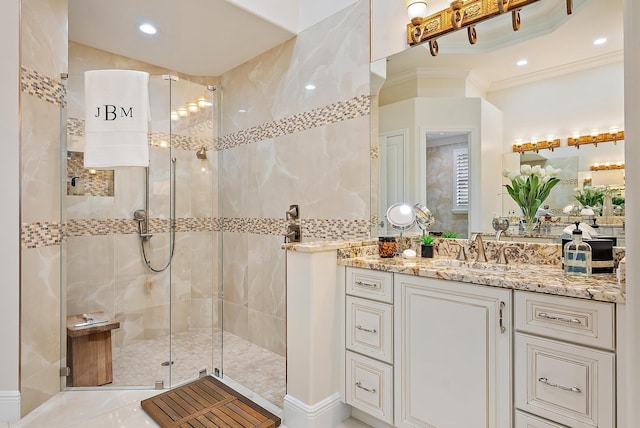 bathroom featuring a shower with shower door, ornamental molding, and vanity