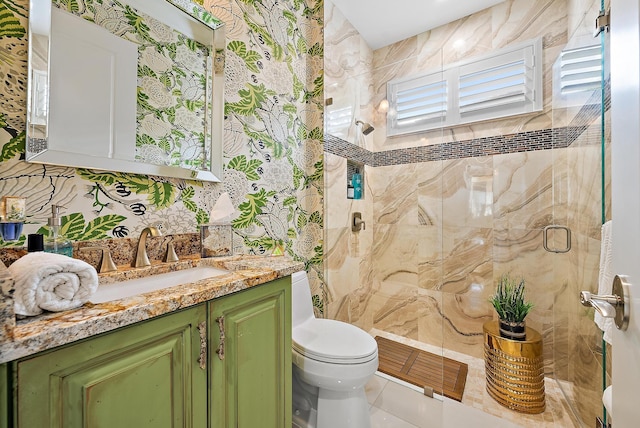 bathroom with tile patterned floors, vanity, a shower with shower door, and toilet