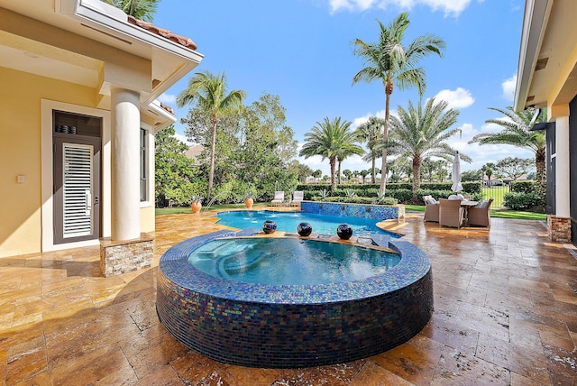 view of pool with an in ground hot tub and a patio