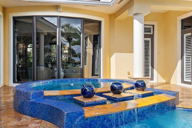 exterior space featuring a skylight and a pool with hot tub