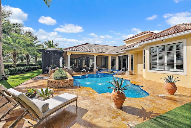 view of swimming pool with a sunroom, pool water feature, a patio, and an in ground hot tub