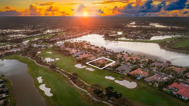 aerial view at dusk featuring a water view