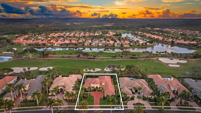 aerial view at dusk featuring a water view