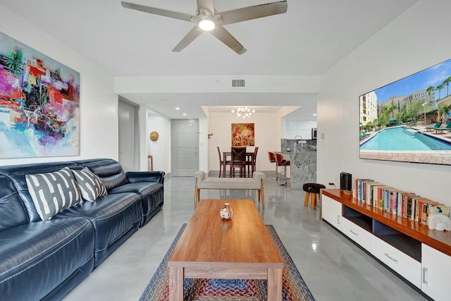 living room with ceiling fan with notable chandelier