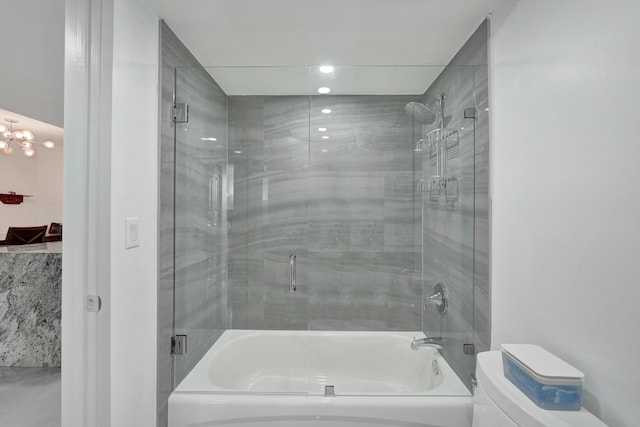 bathroom with toilet and combined bath / shower with glass door