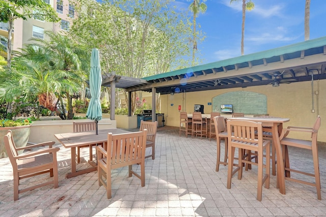 view of patio / terrace featuring ceiling fan and exterior bar