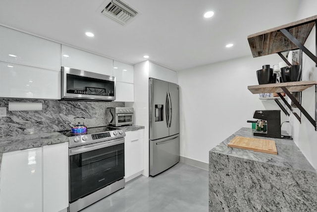 kitchen featuring white cabinetry, backsplash, light stone counters, and stainless steel appliances