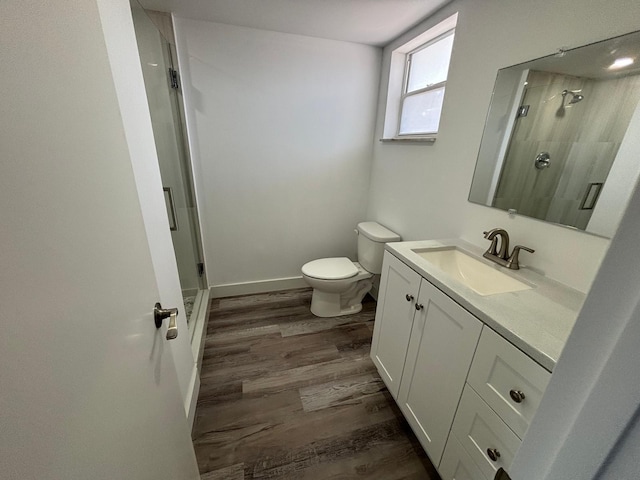 bathroom with wood-type flooring, vanity, toilet, and walk in shower