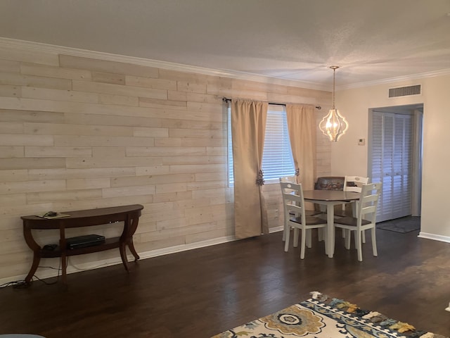 dining area with wood walls, dark wood-type flooring, and ornamental molding