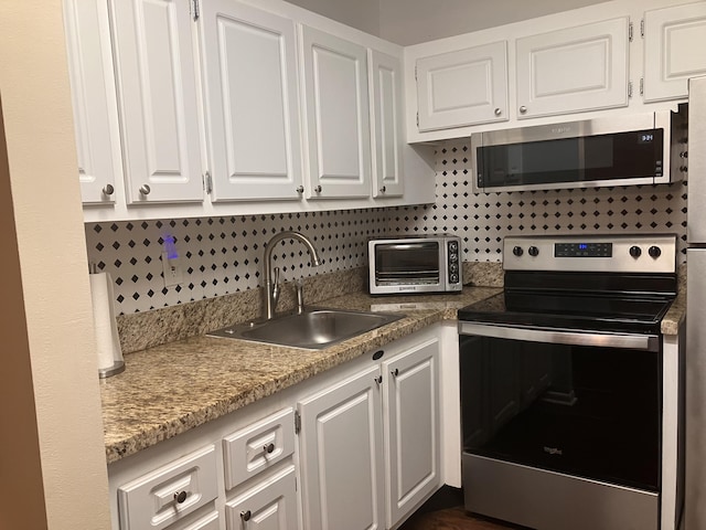 kitchen featuring white cabinets, decorative backsplash, sink, and appliances with stainless steel finishes