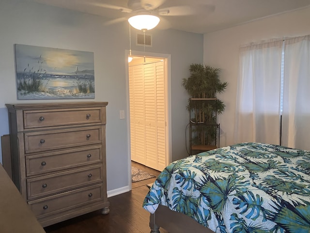 bedroom with dark hardwood / wood-style flooring, a closet, and ceiling fan